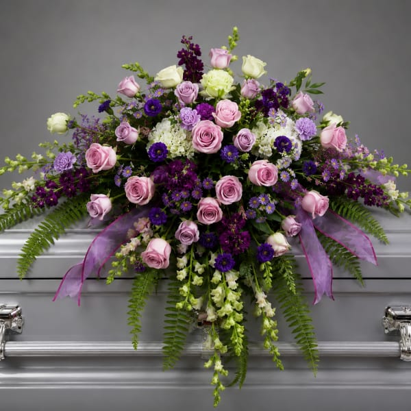 Pink and purple floral spray on a silver casket
