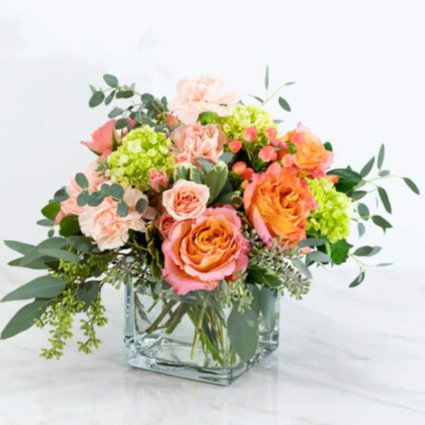 Mixed bouquet of pink and orange roses in a clear glass vase