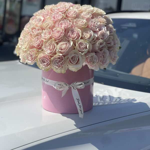 Pink rose bouquet in a round pink box with a white ribbon