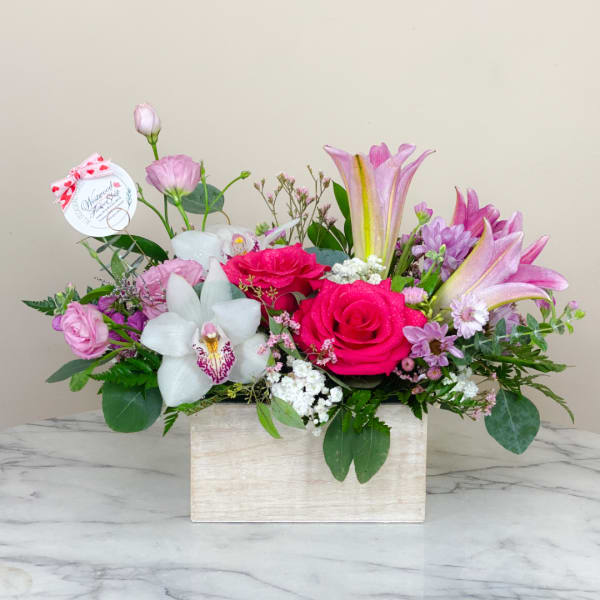 Pink and white floral arrangement in a rectangular wooden box