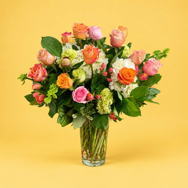 Mixed roses and hydrangeas in a clear glass vase