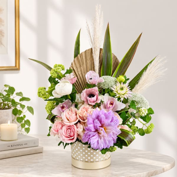Pink and lavender floral arrangement in a polka-dot vase