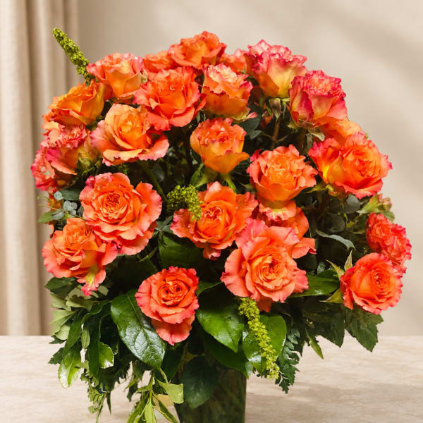 Orange roses arranged in a clear glass vase