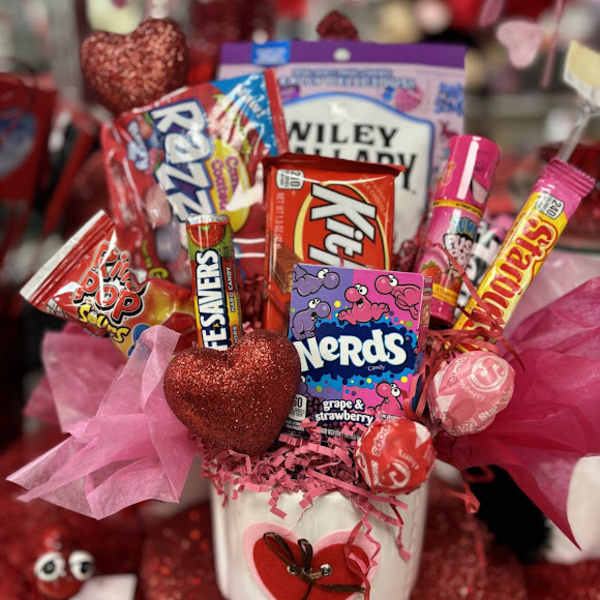 Candy bouquet in a white pot with pink tissue and heart decorations
