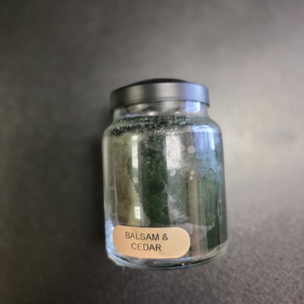 Glass jar candle labeled Balsam & Cedar