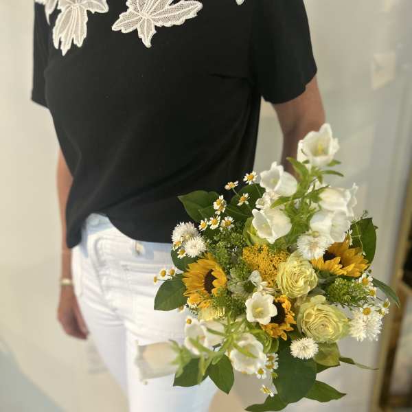 Handheld bouquet with sunflowers, white blooms, and pale yellow roses