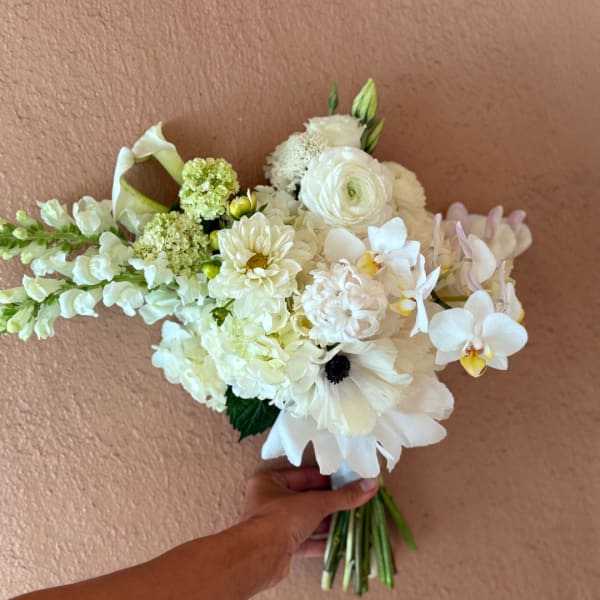 White bridal bouquet with orchids, calla lilies, and mixed blooms