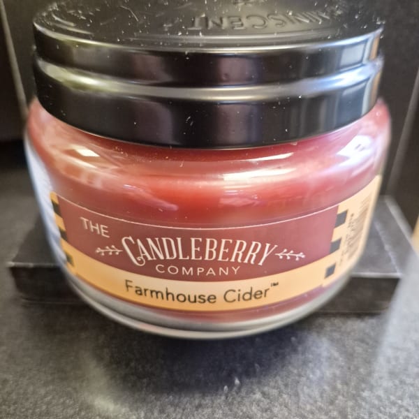A jar candle labeled Farmhouse Cider from The Candleberry Company