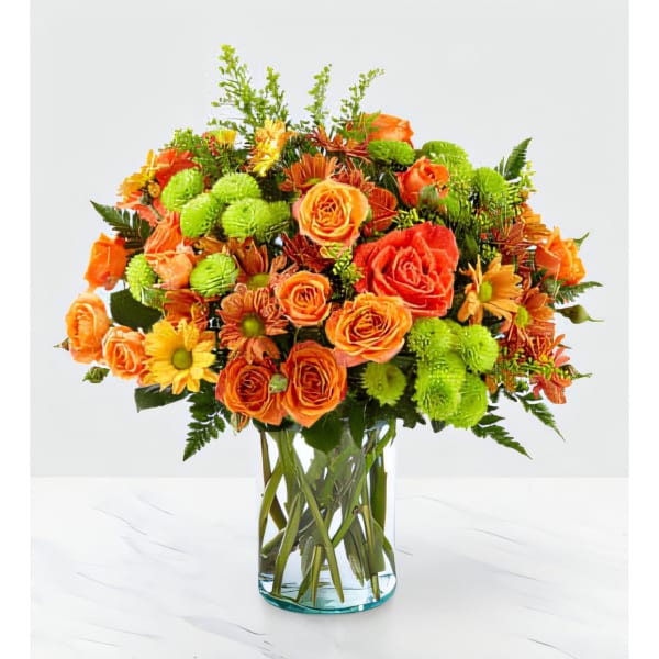 Orange and yellow mixed flower bouquet in a clear glass vase