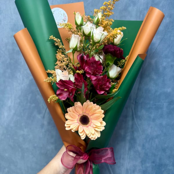 Handheld bouquet with peach gerbera, white roses, and magenta alstroemeria
