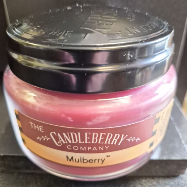 Pink jar candle with a black lid labeled Mulberry