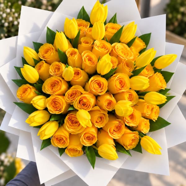 Bouquet of yellow roses and tulips wrapped in white paper