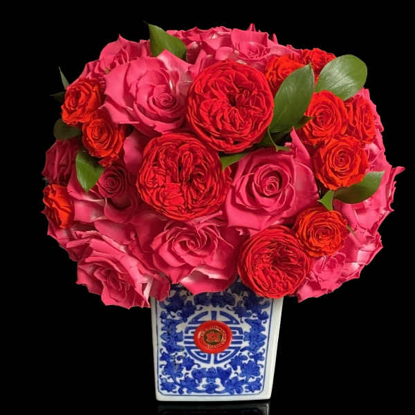 Pink and red rose bouquet in a blue-and-white ceramic vase