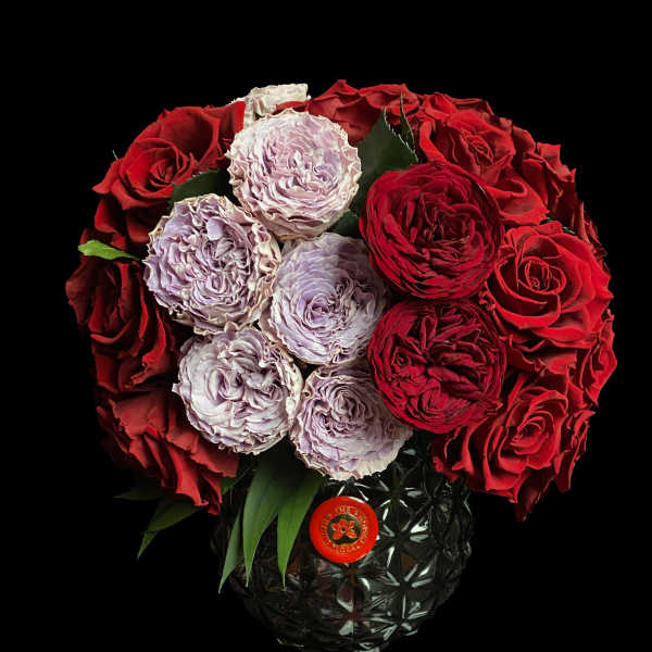 Red and lavender roses arranged in a black vase