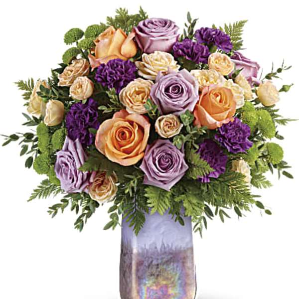 Bouquet of peach, lavender, and purple roses in a tall iridescent vase