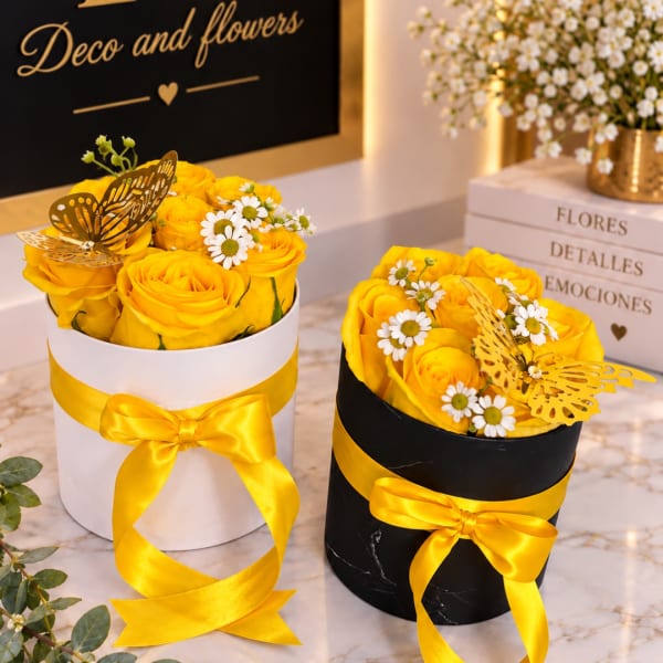 Yellow rose arrangements in round gift boxes with ribbon and butterfly toppers