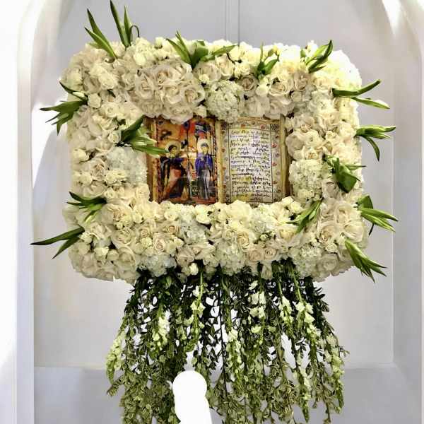 Large white floral frame around a religious icon with trailing greenery