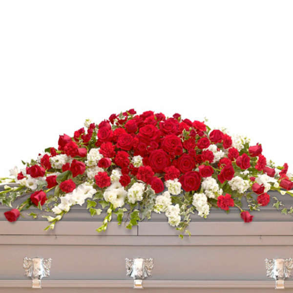 Red and white casket spray with roses and other flowers on a gray casket