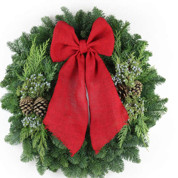 Evergreen wreath with pinecones, white berries, and a large red bow