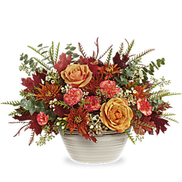 Autumn floral arrangement in a white ceramic bowl with orange and pink blooms