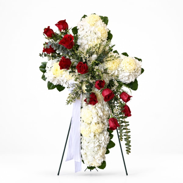 Standing floral cross with red roses and white hydrangeas on an easel