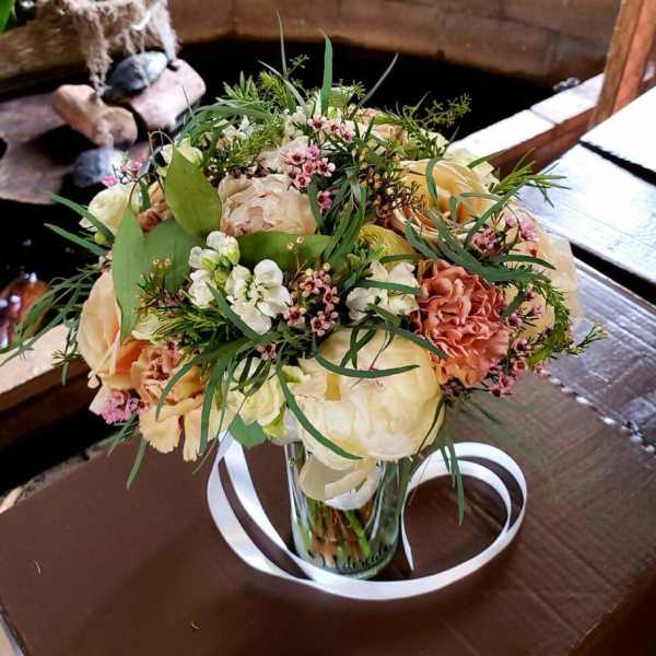 Bouquet of peach and white flowers in a clear glass vase