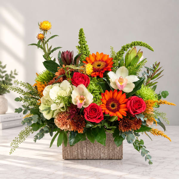 Colorful mixed flower arrangement in a textured rectangular vase