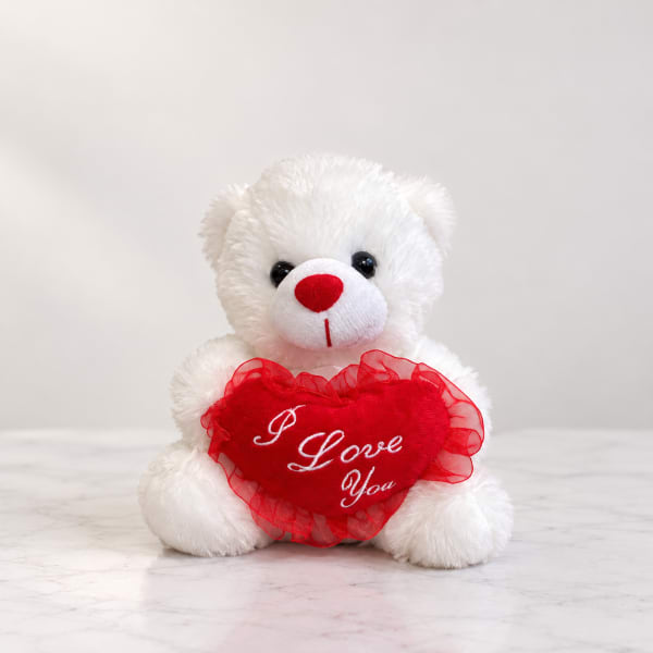 White teddy bear holding a red heart with "I Love You" text