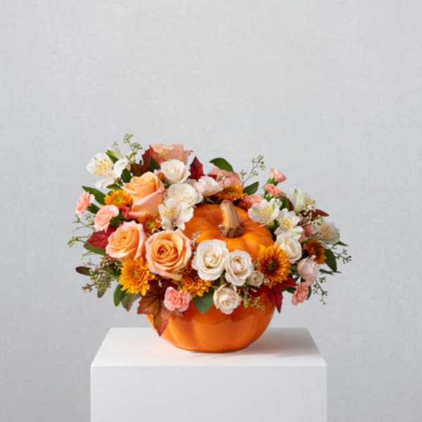 Mixed flowers arranged in an orange pumpkin-shaped vase