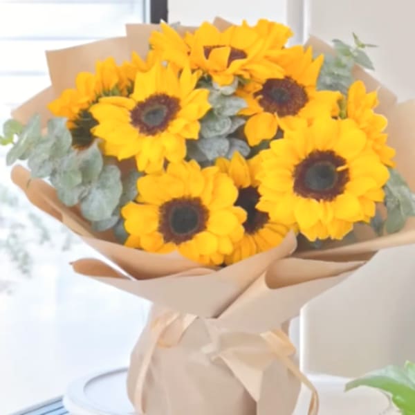 Bouquet of yellow sunflowers wrapped in beige paper