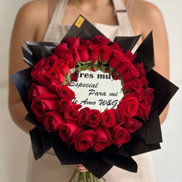 Heart-shaped bouquet of red roses with a printed message card