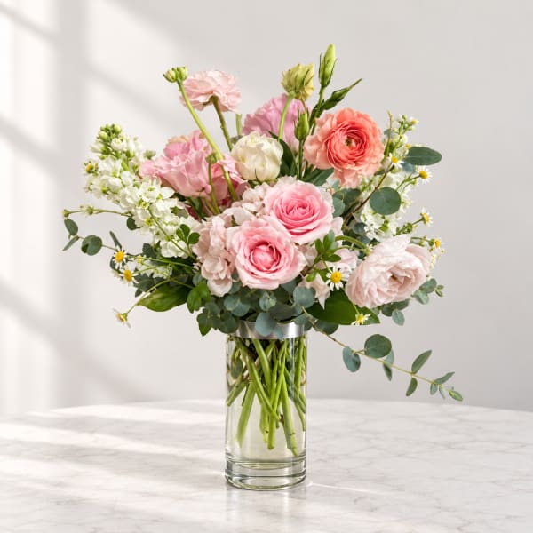 Pink and white flower arrangement in a clear glass vase