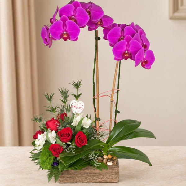 Orchid and rose arrangement in a wooden box with a heart pick