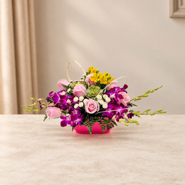 Pink roses and purple orchids in a bright pink container