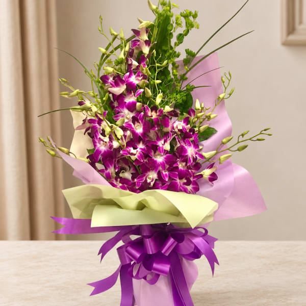 Purple orchid bouquet wrapped in pastel paper with a ribbon