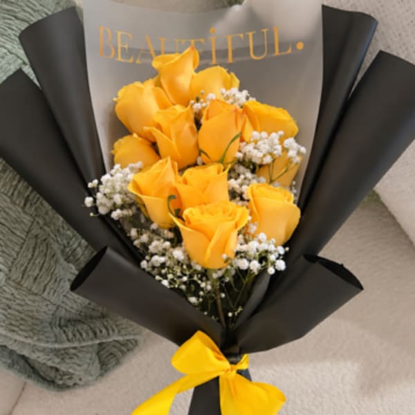 Bouquet of yellow roses wrapped in black paper with a yellow ribbon