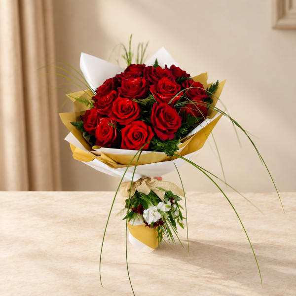 Bouquet of red roses wrapped in white and gold paper