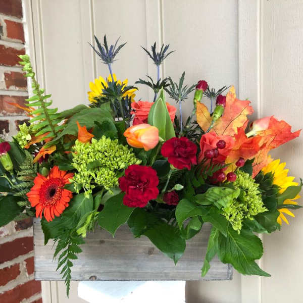 Colorful mixed flower arrangement in a rustic wooden box