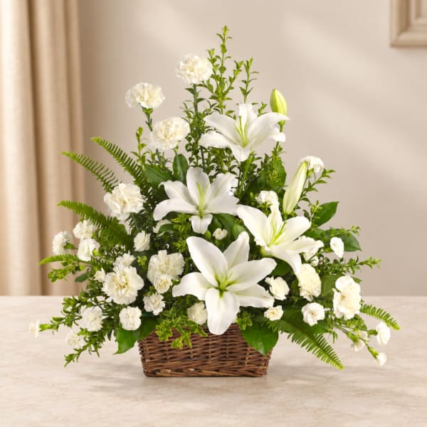 White lilies and carnations in a wicker basket