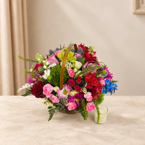 Basket arrangement of mixed pink, red, white, and blue flowers