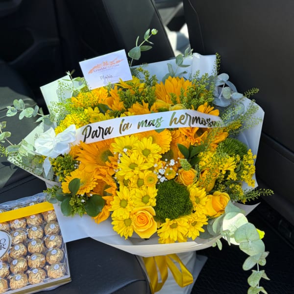 Yellow bouquet with daisies and roses, wrapped in white paper with a ribbon
