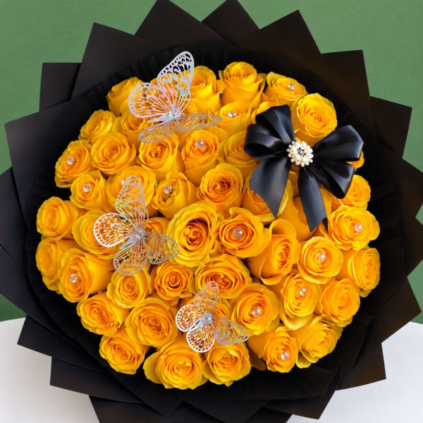 Bouquet of yellow roses with butterfly decorations and a black ribbon bow