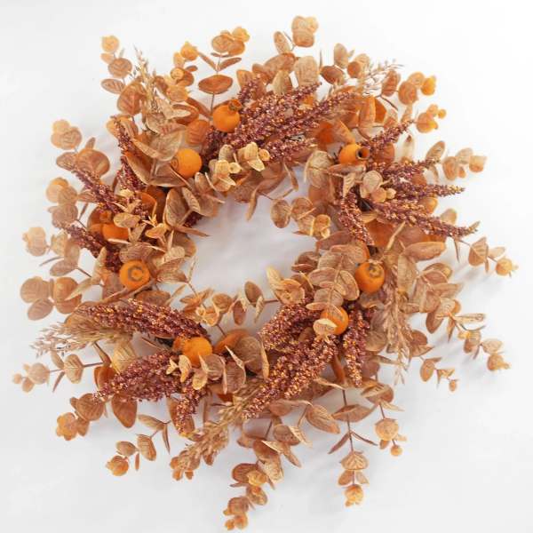Autumn wreath with orange berries and dried foliage on a white background