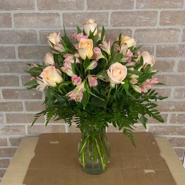 Peach roses and pink alstroemeria in a clear glass vase