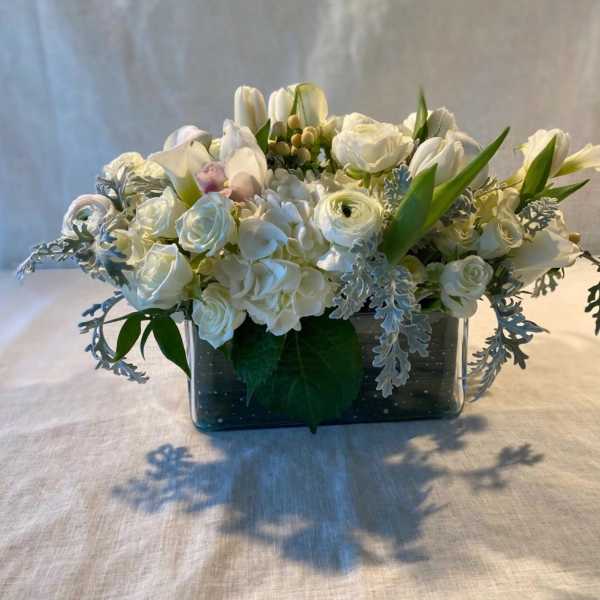 White floral arrangement in a rectangular glass vase