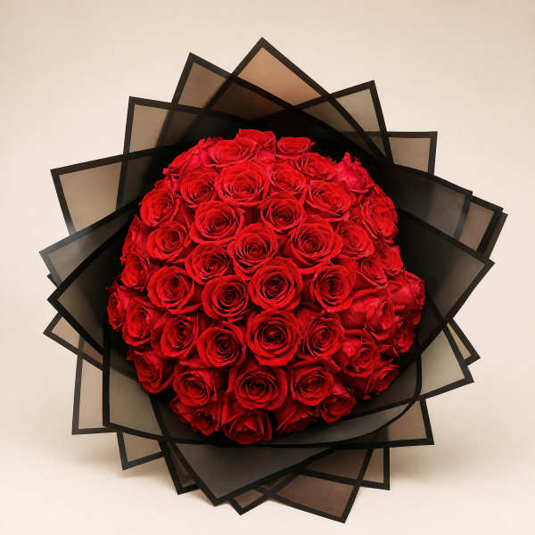 Round bouquet of red roses wrapped in black paper