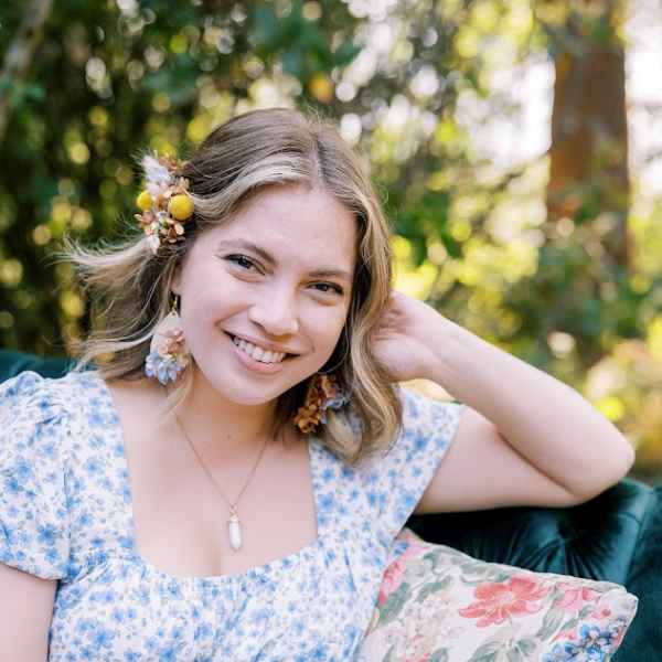 Woman wearing floral hair accessories and earrings outdoors