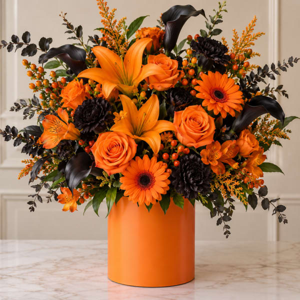 Orange flowers in a round orange vase with dark accents