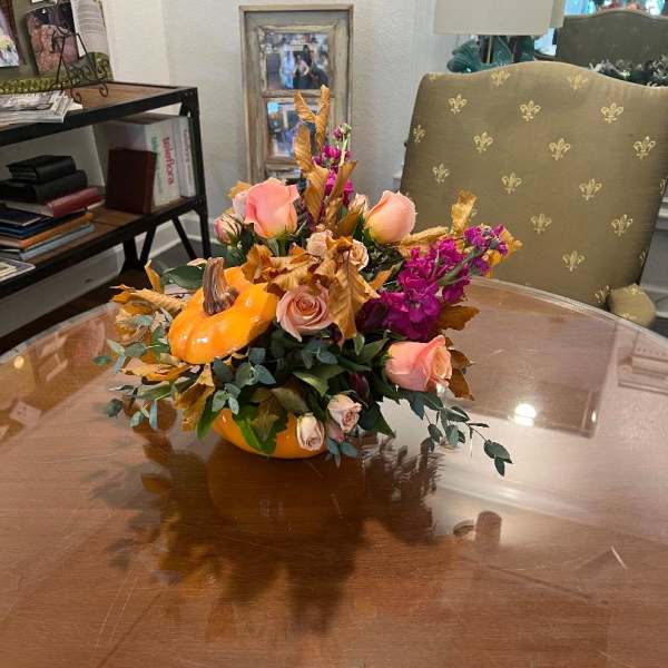 Pumpkin-shaped floral arrangement with peach roses and purple blooms