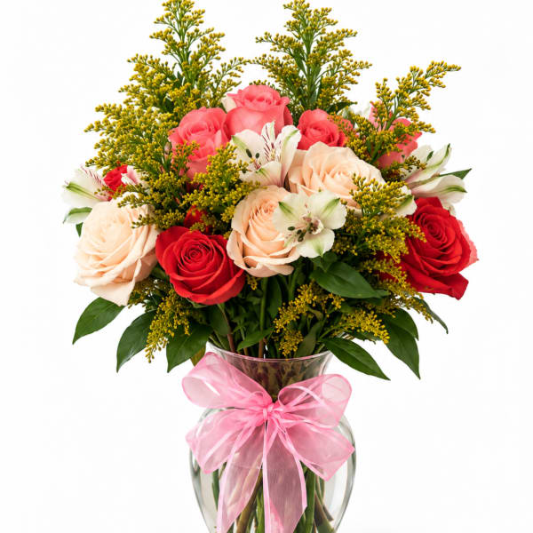 Bouquet of pink, red, and peach roses in a glass vase with a pink bow
